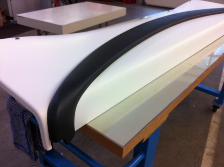 Bauteil mit Vollfolierung in Weiß und Schwarz auf der Werkbank