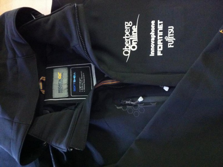 Schwarze Softshelljacke mit Logos von Oberberg Online, innovaphone, Fortinet und Fujitsu