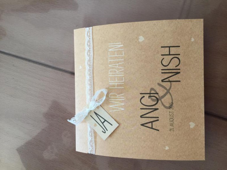 Hochzeitseinladung aus Kraftpapier mit Spitzenband und Anhänger
